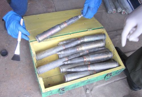 Следователи-криминалисты осматривают изъятые боеприпасы.