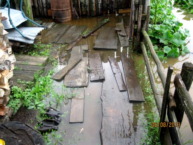 С одной стороны улицы Биракана заливает вода из ключа, а с другой - вода из протоки Биры