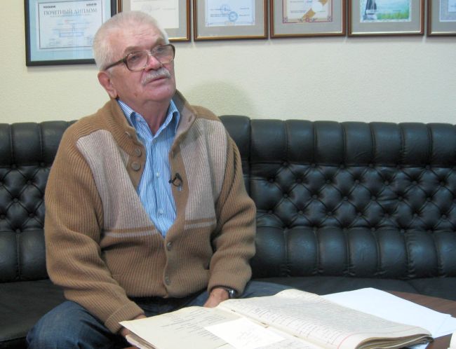 Журналист Александр Чернявский листает книгу приказов «ТОЗа».