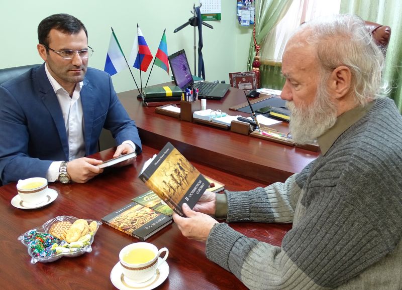 Книги в дар Дагестану от хабаровского писателя Владимира Иванова Ардашева (справа) принимает постпред Бейдулах Исаев.